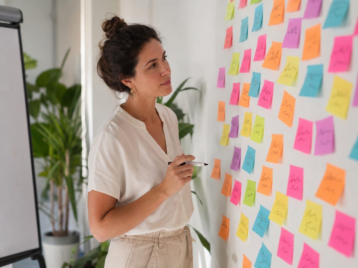 A team member planning at a whiteboard covered in sticky notes