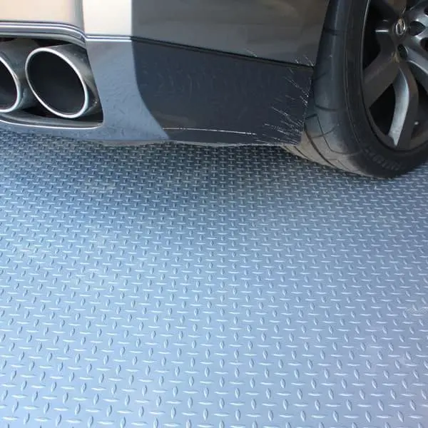 Car tire and body over Stainless Steel diamond-pattern vinyl garage flooring.