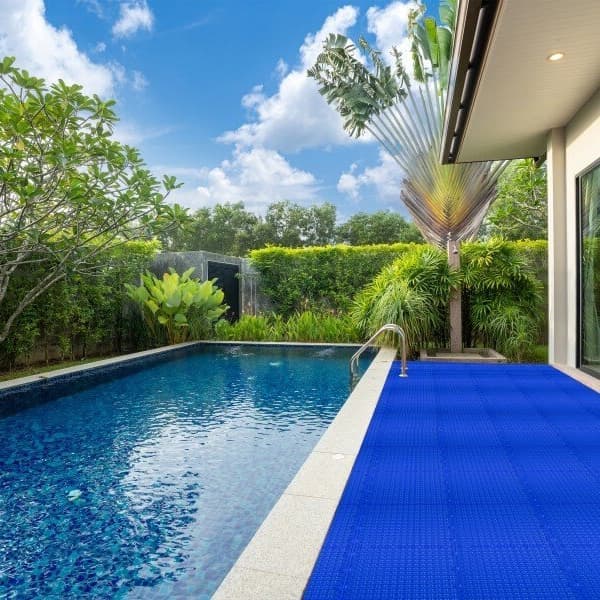 Poolside deck with Rugged Grip-Loc Tiles in Shelby Blue, textured surface beside swimming pool and modern house