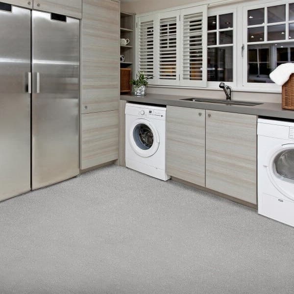 Mannington BioSpec 6'6" vinyl sheet flooring in light gray — laundry room with washer, dryer, and stainless steel