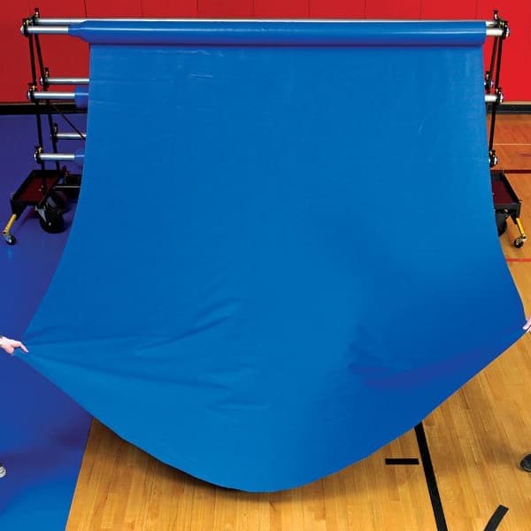 Royal blue gym floor cover unrolled on a wooden gym floor