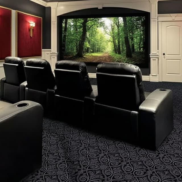 Joy Carpets Damascus Carpet, black — home theater room with patterned nylon carpet under recliner seats and large screen
