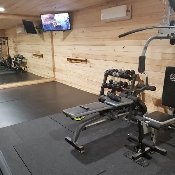 Black rubber gym mats in at-home gym.