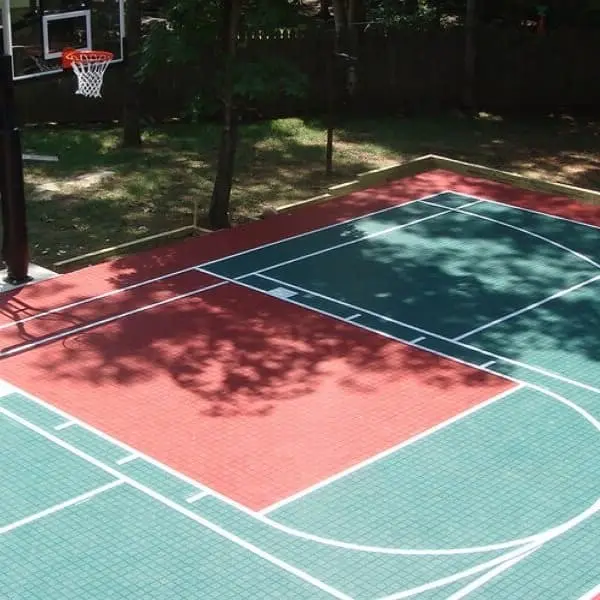 Outdoor basketball court with Premium Outdoor Sports Tiles in green and red, white lines marking play areas