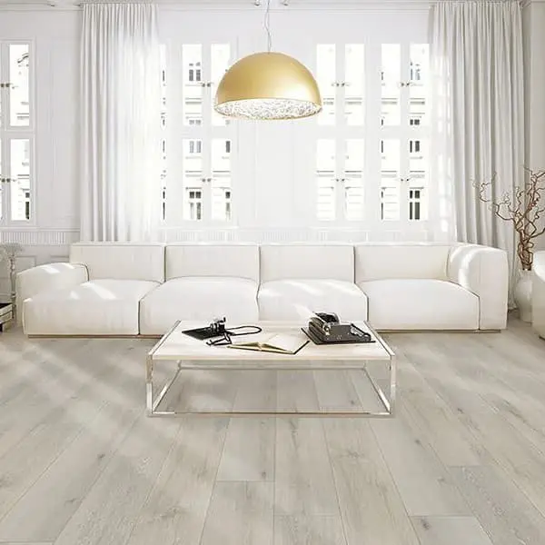 Rigid core vinyl plank flooring in living room with white sectional sofas, glass coffee table, and large windows with sheer white curtains.