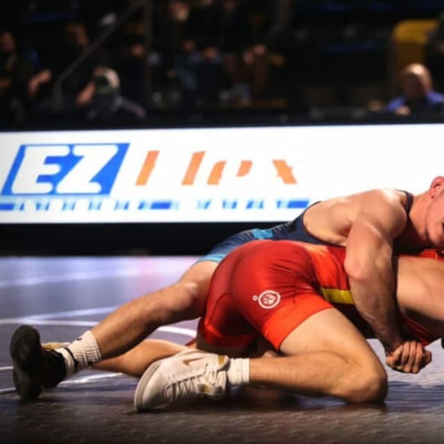 Wrestling mat being used by two male wrestlers competing during a match.