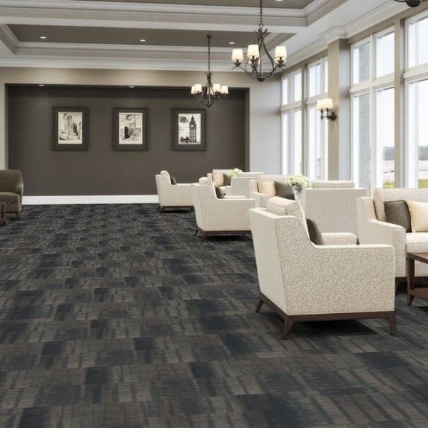 Lobby with J&J Flooring Well Versed Carpet Tile in Ashbery, dark gray and charcoal linear pattern under seating and tables