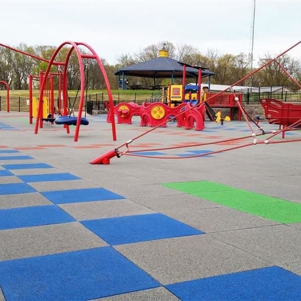 PlaySafe interlocking rubber tiles in gray, blue, and green, with red playground equipment