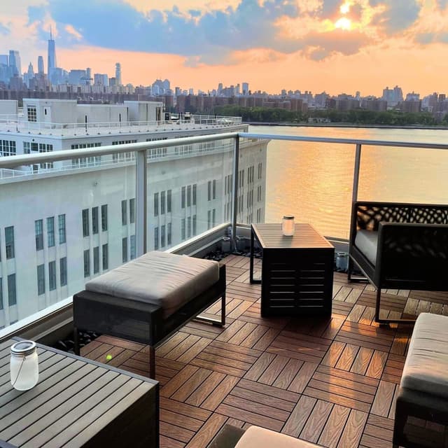 Rooftop deck with NewTechWood UltraShield 12" x 12" composite deck tiles, featuring outdoor furniture and city skyline view