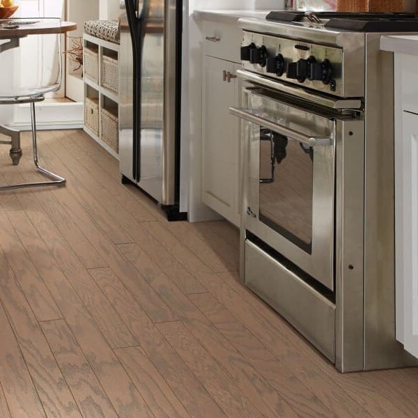 Shaw Albright Oak Engineered Wood in Caramel — kitchen with white cabinets and stainless steel appliances