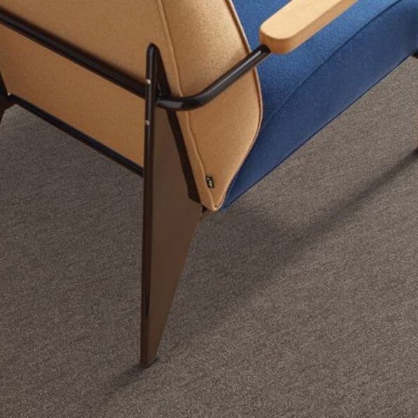 Shaw Profusion Carpet Tile, Heaps — gray carpet tile under a modern chair in an office setting