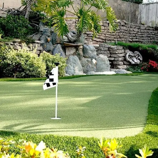 Backyard putting green with Golf Green artificial turf, featuring checkered flags