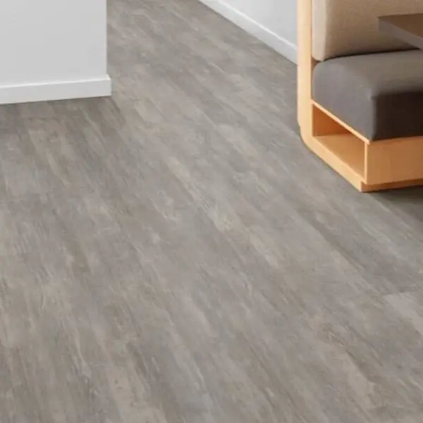 Shaw Purview 6" Luxury Vinyl Planks — gray wood grain pattern, installed in a living room under modern seating and side table