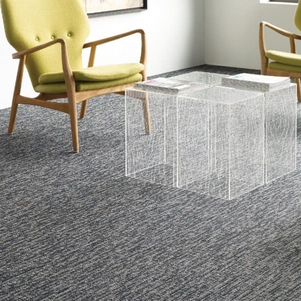 Shaw Function Carpet, Conservative — office lounge with gray textured carpet under green chairs and wireframe coffee table