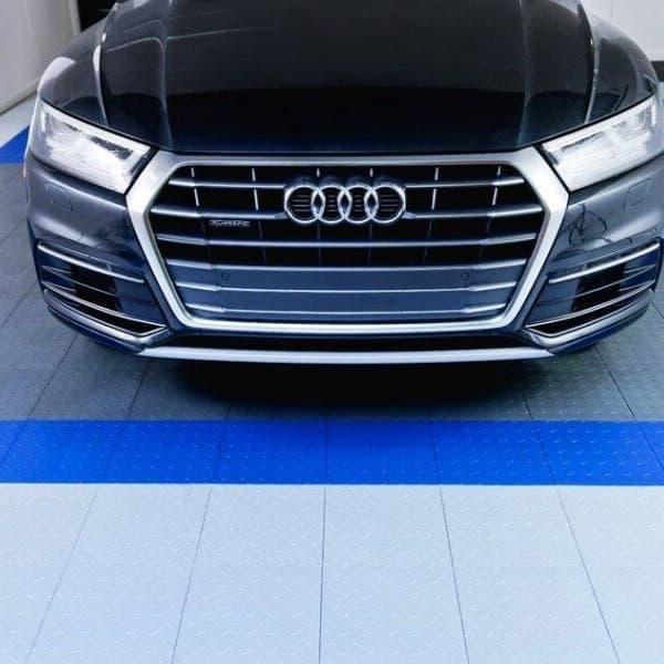 Garage with Flooring Inc Octane Tiles in Slate Gray and Royal Blue, featuring a black Audi parked on the tiled floor
