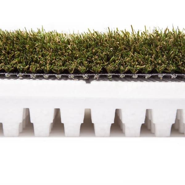 Shaw Play Pad 8 artificial grass — green polypropylene turf with white foam backing, close-up side profile view