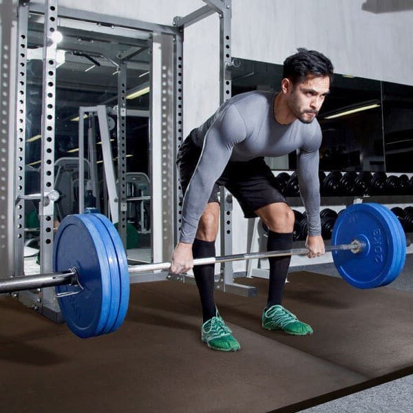 Athlete deadlifting on gym mat.