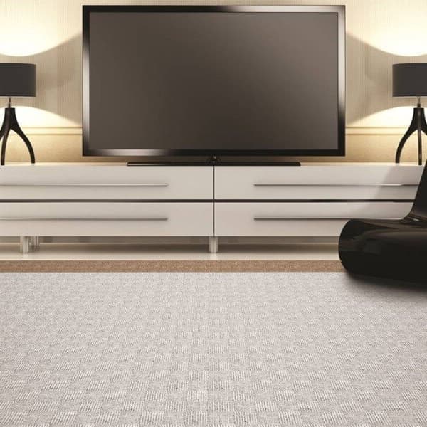 Weave carpet tiles in a minimalist living room with a black chair, a TV, and a TV stand.