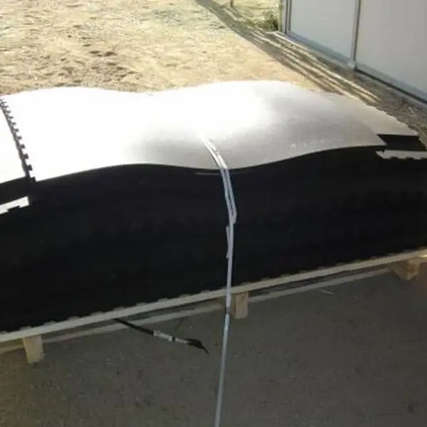 3/4" Eco Pebble Top Horse Stall Mat kit — black interlocking mats stacked on pallet