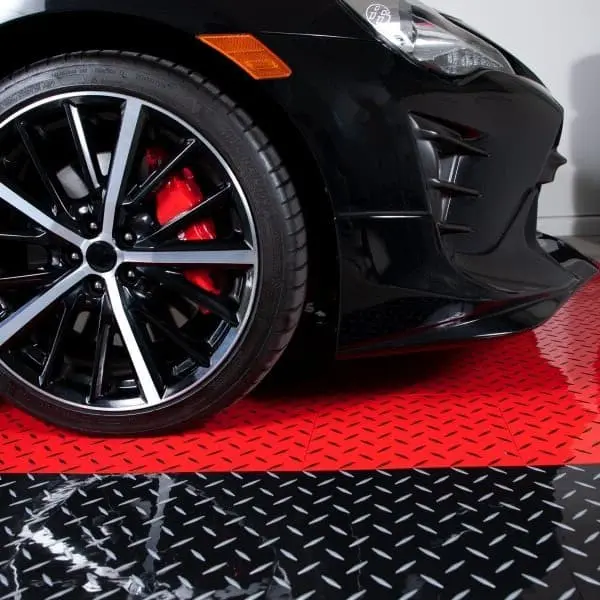 Garage with black car on red and black diamond plate Nitro Tiles Pro flooring
