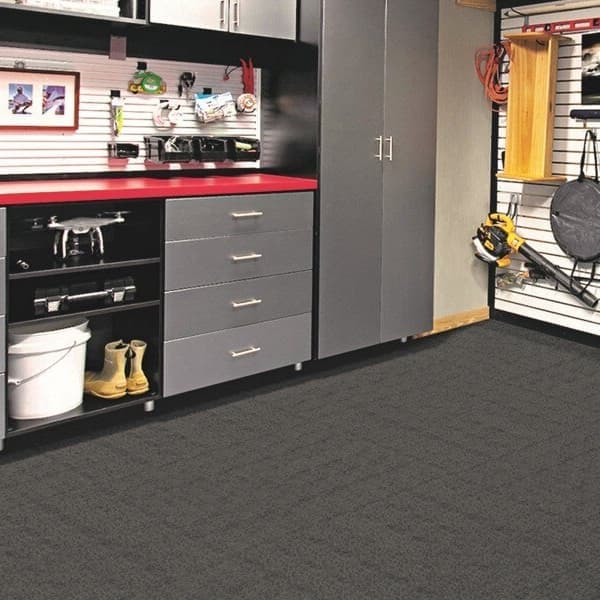 Garage with Foss Premium Ribbed Carpet Tiles in Smoke, covering the floor beneath gray storage cabinets and tool wall