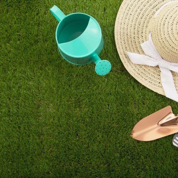 Helios artificial grass deck tiles, green — gardening tools and straw hat on grass