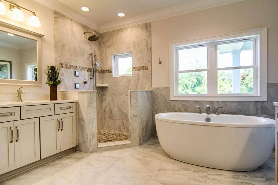 Bathroom with marble-look tile walls, a walk-in shower and a freestanding tub