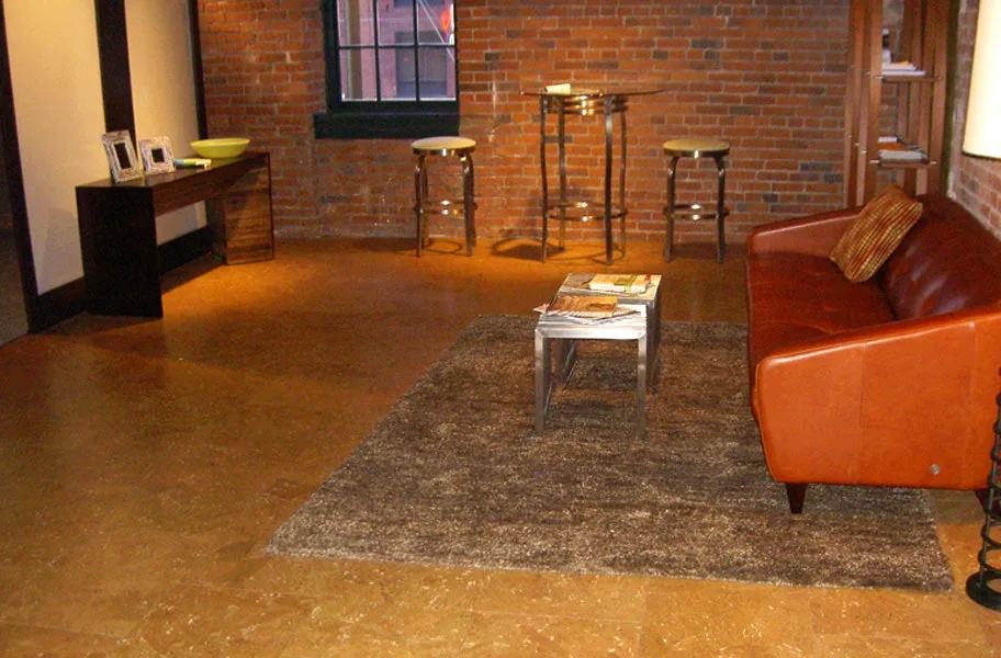 Cork tile floor in a loft with an exposed brick wall, leather sofa and shag rug