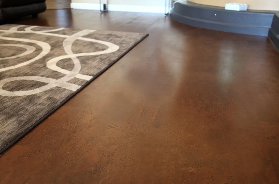 Brown cork flooring in a living room with a patterned rug and gray baseboard trim