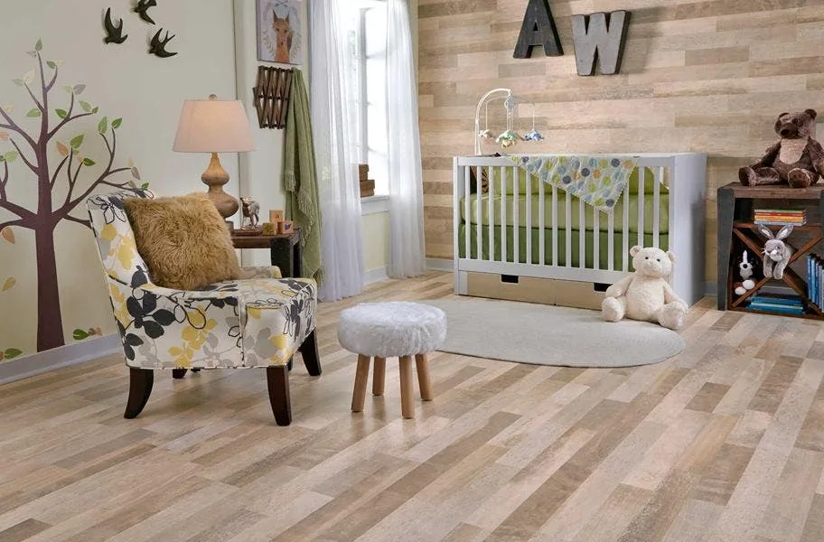 Shop Mannington Whiskey Mill Waterproof Laminate nursery scene of light laminate flooring, a chair, stool, and a crib with toys