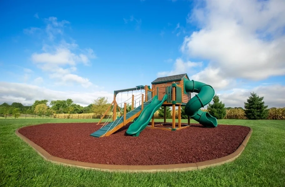 A playground set showcasing our playground rubber mulch in an attractive brown color.
