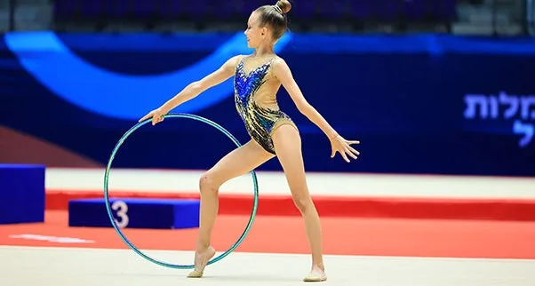 Gymnastics and Tumbling Mats Gymnastics mat or tumbling mat provides a cushioned and professional surface for a young rhythmic gymnast during a performance with a hoop.