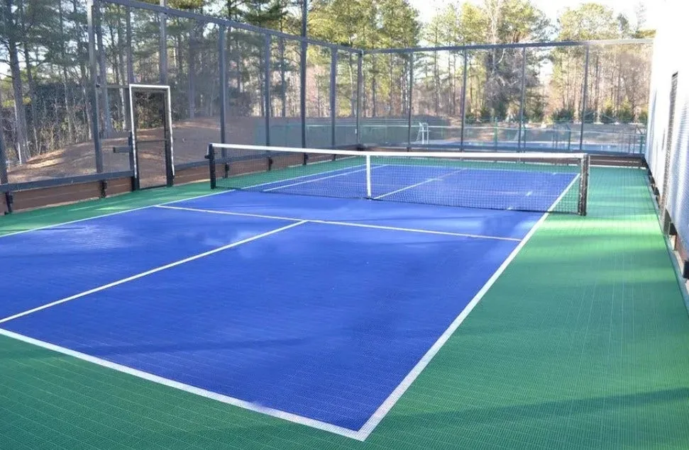 Interlocking tennis and pickleball court tiles in vibrant blue and green, creating a durable and all-weather playing surface in an outdoor residential backyard.