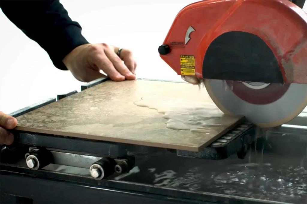 Cutting a ceramic floor tile with a wet saw