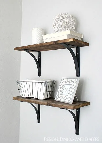 Two rustic wood plank shelves on black brackets holding a wire basket and decor