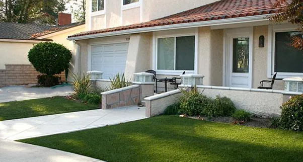 Interlocking Decking Tiles & Durable Outdoor Turf Interlocking deck tiles in a composite wood grain finish, creating an elevated and professional surface on a patio or balcony & Durable outdoor turf in a front yard, creating a low-maintenance, drought-friendly, and vibrant green lawn alternative for resi