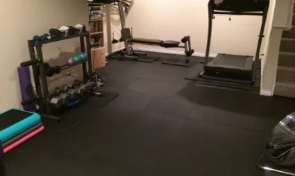 Durable Rubber Gym Flooring Durable black rubber gym flooring tiles create a protective and shock-absorbent surface in a home gym, suitable for a weight rack, cardio machines, and other exercise equipment.
