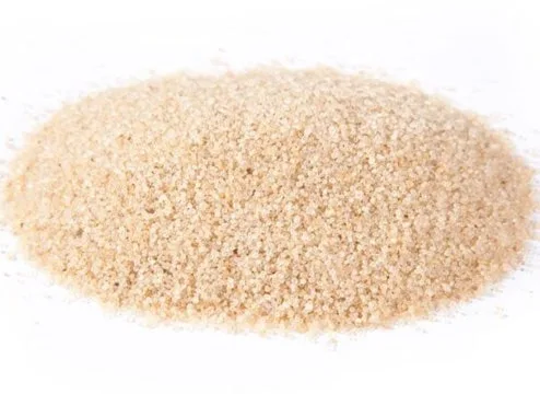 A close-up shot of Hyrdochill Cooling Sand turf infill, showing the small granules used to weigh down and support the blades of artificial grass on sports fields and lawns.