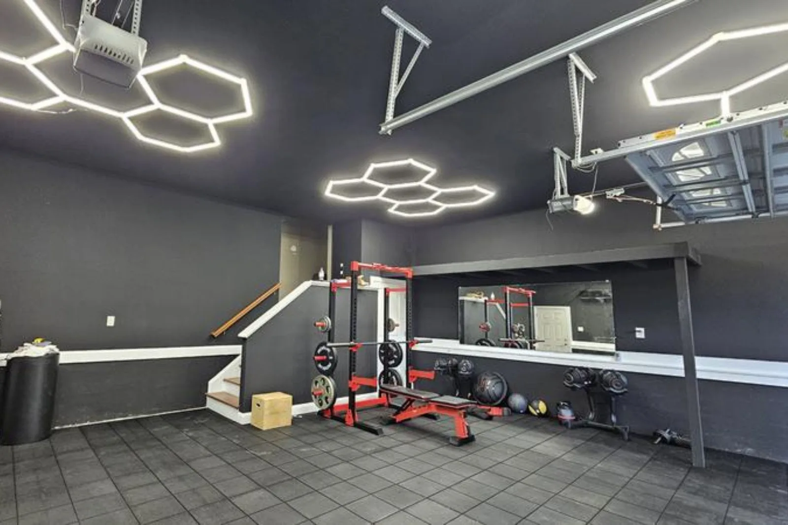 Garage gym with hexagon lights and a squat rack on 5/8-inch Evolution rubber floor tiles