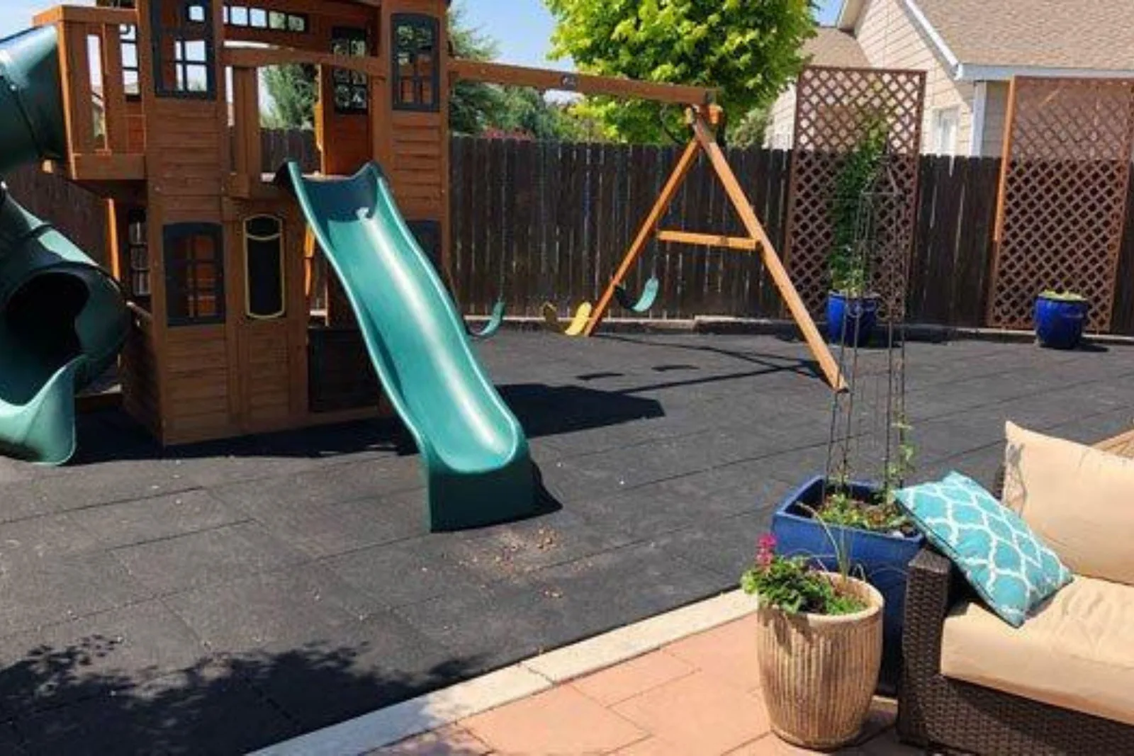 Backyard play set with a slide on Jamboree rubber playground tiles