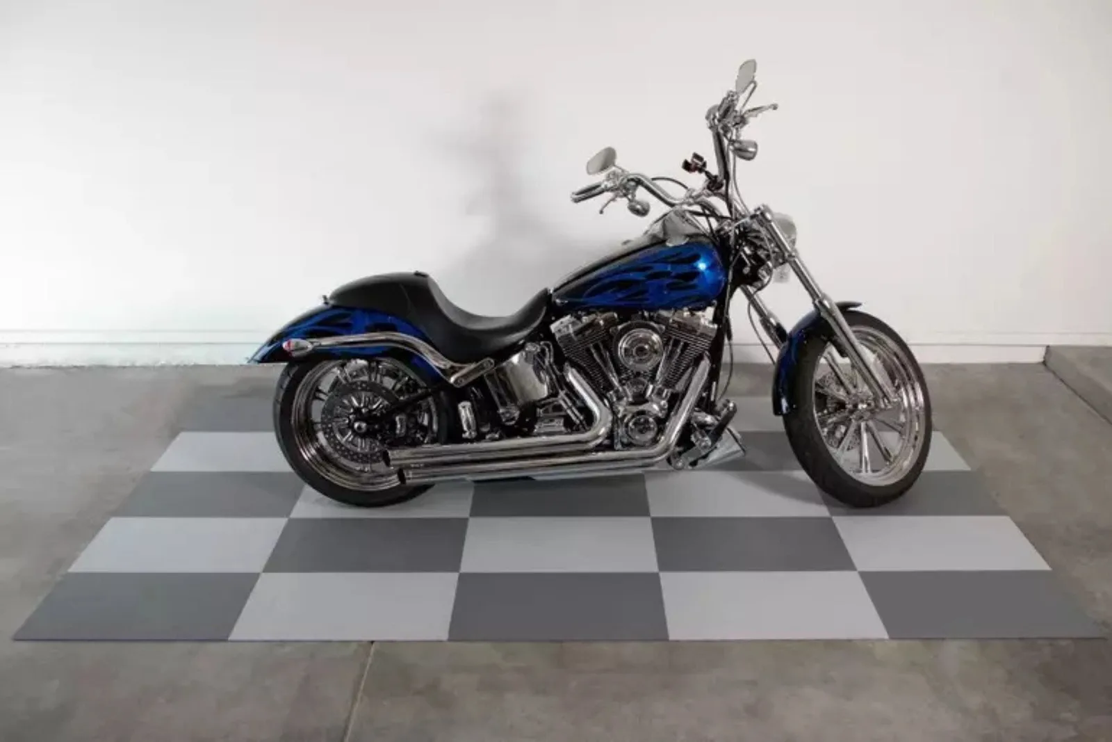 Motorcycle parked on gray checkerboard flexible garage floor tiles