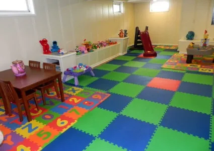Colorful interlocking foam floor tiles in a checkered pattern, creating a safe and vibrant playroom flooring for kids in a daycare or basement play area.