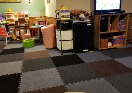 Interlocking foam carpet tiles in a checkered pattern, offering a soft and insulated flooring solution for a basement playroom.