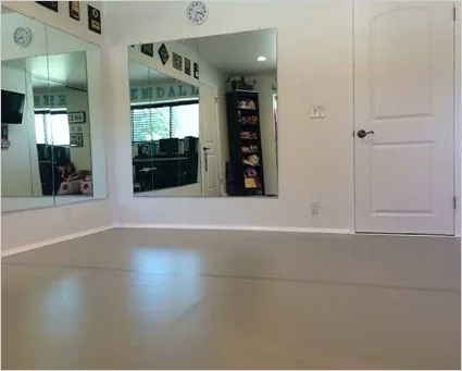 Home ballet studio with wall mirrors and a gray marley dance floor