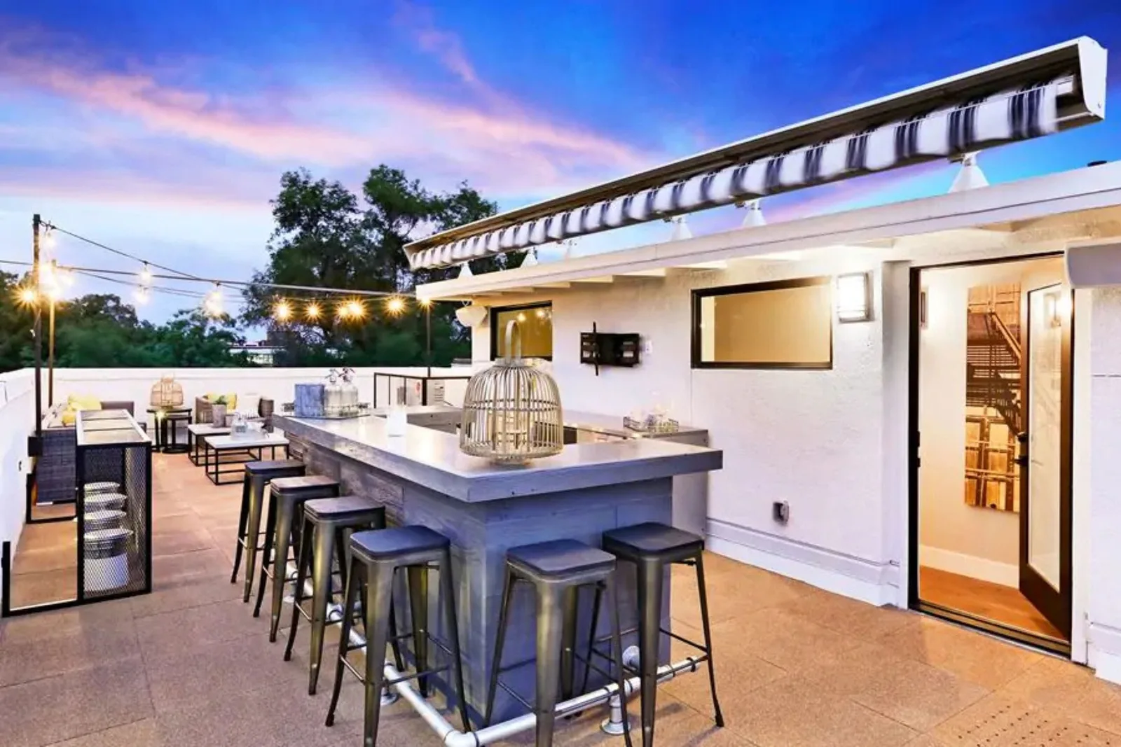 Rubber tile rooftop decking in a neutral color creates a stylish and durable outdoor flooring solution for a modern rooftop bar and lounge area.