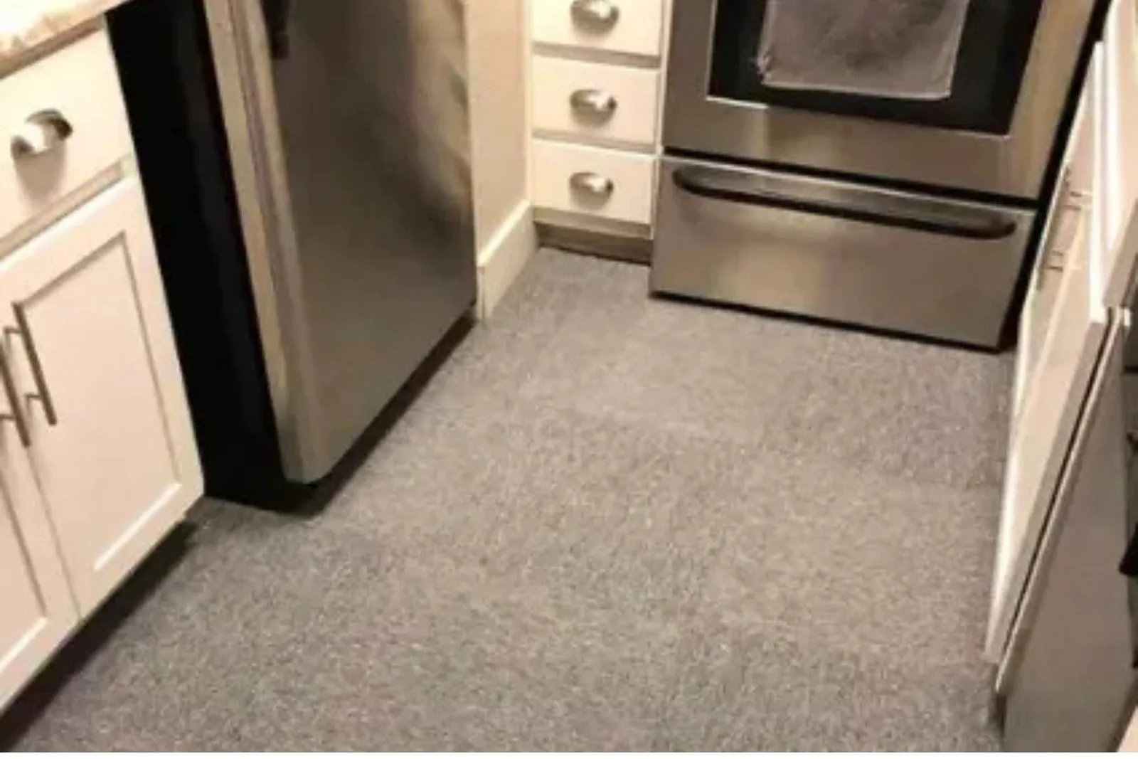 Small kitchen with a durable gray textured carpet, a functional and comfortable residential flooring solution.