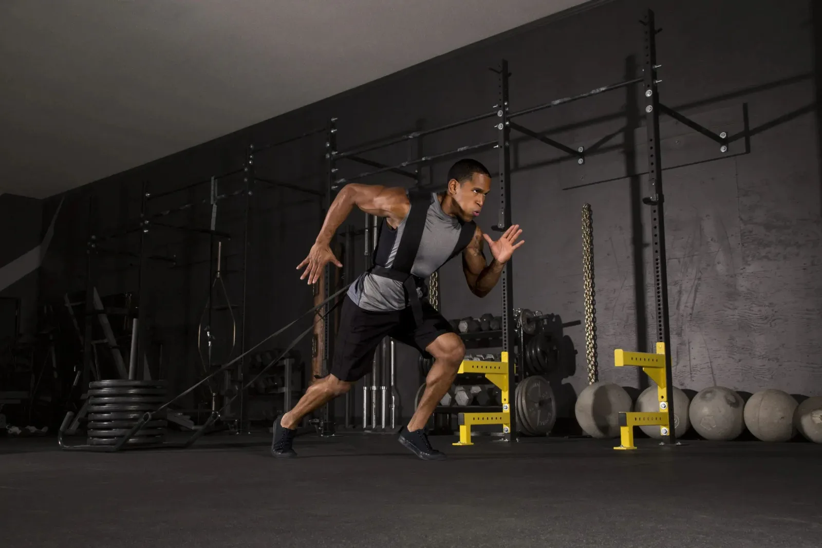 Person sprinting in a gym on durable black rubber gym flooring, a high-performance and shock-absorbing flooring solution for a workout space.