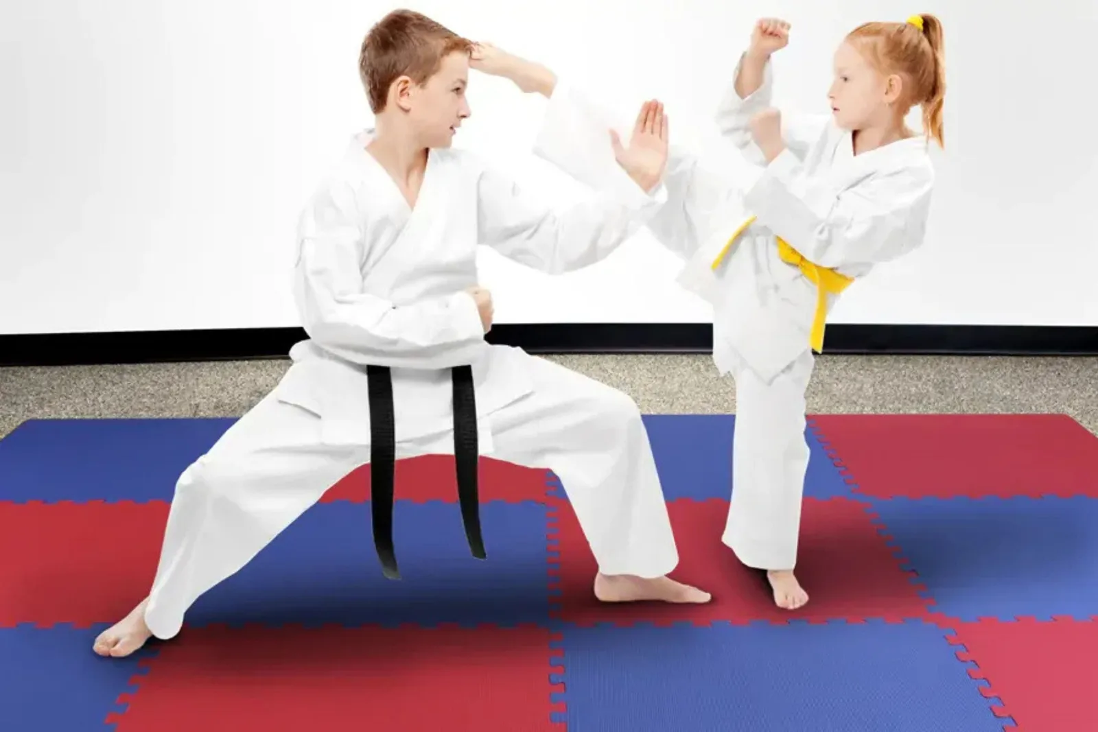 Interlocking foam tiles in red and blue create a safe, shock-absorbent martial arts mat surface for children practicing karate and Taekwondo.
