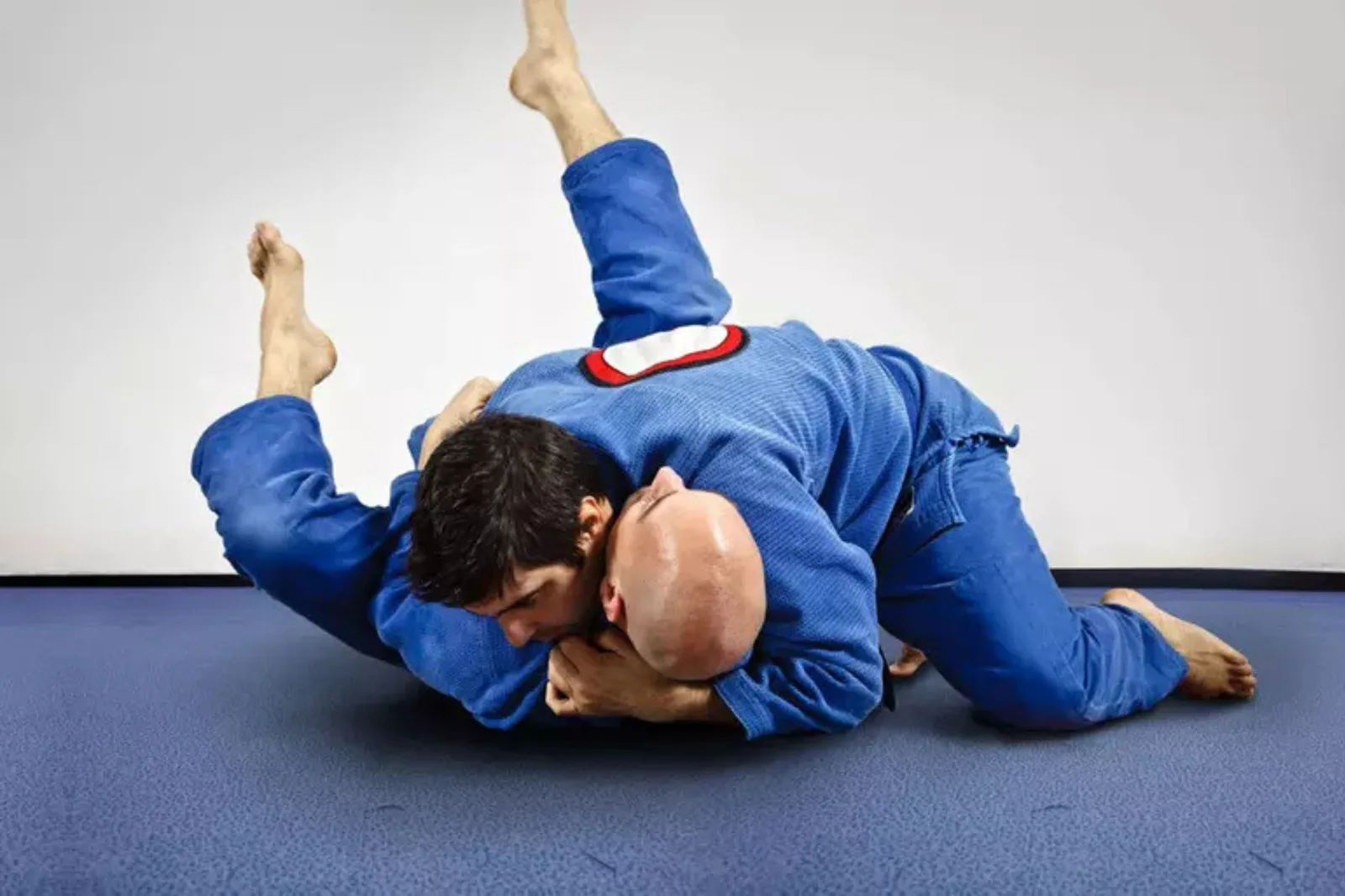 Wrestling mat surface of interlocking foam mats provides a safe and shock-absorbent floor for two athletes grappling during martial arts or wrestling training.