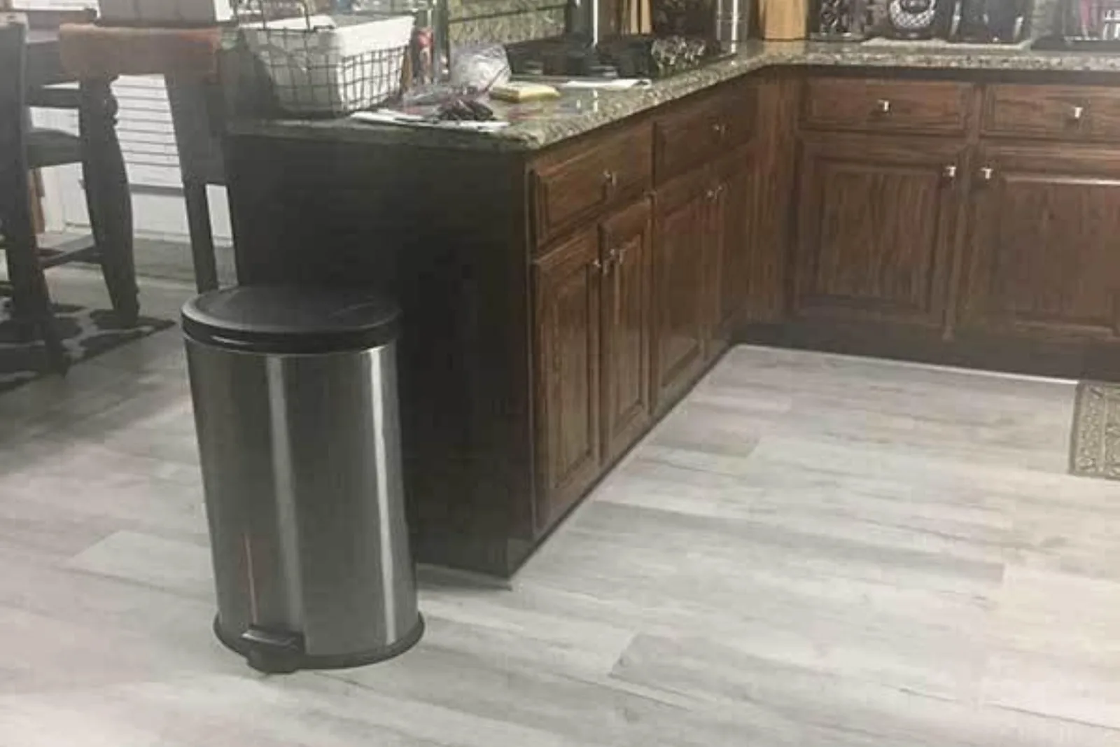Kitchen with durable light gray wood-look vinyl plank flooring, a water-resistant and easy-to-clean alternative to hardwood in high-traffic areas.